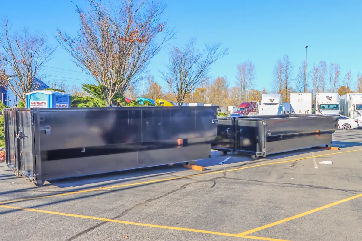 Professional dumpster rental service with roll-off container on residential driveway in Muscle Shoals